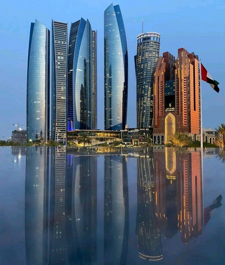 Etihad Towers reflected in water with UAE flag in Abu Dhabi City