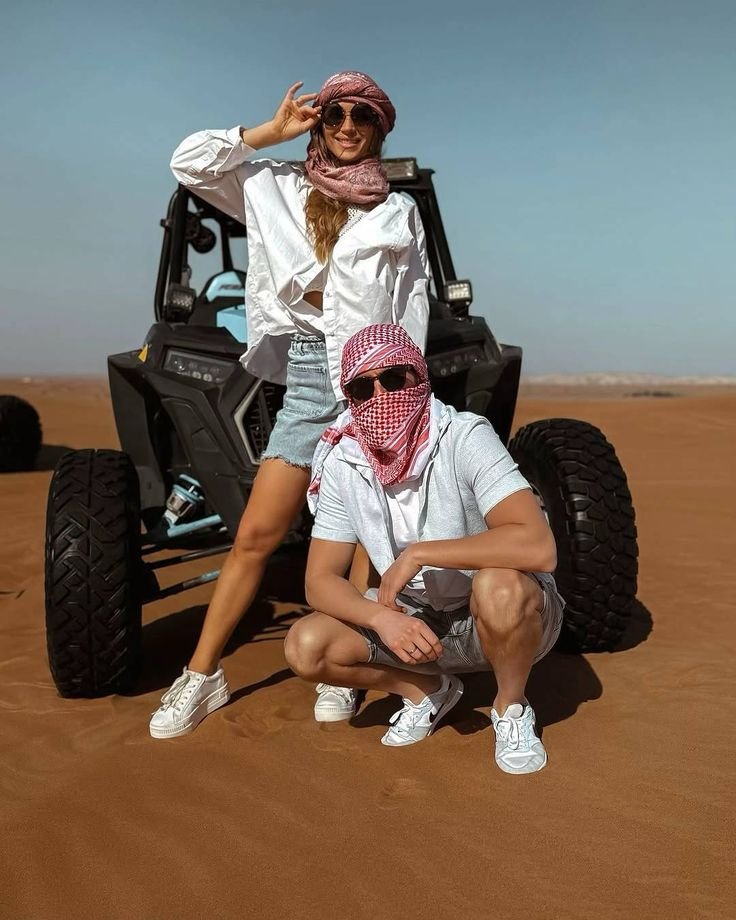 Couple posing with a dune buggy in the desert