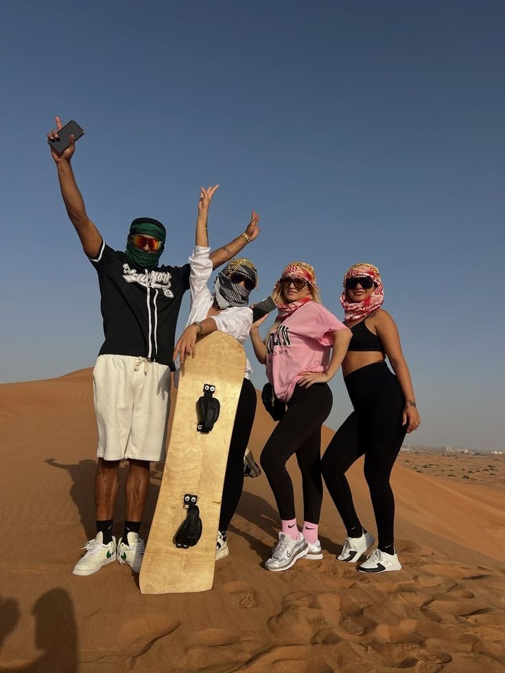 Friends with a sandboard on the desert dunes