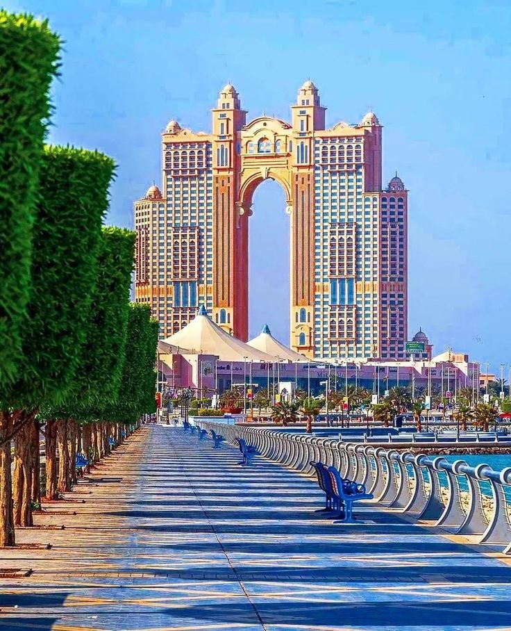 Palm-lined promenade and archway with Abu Dhabi waterfront towers on the tour from Dubai