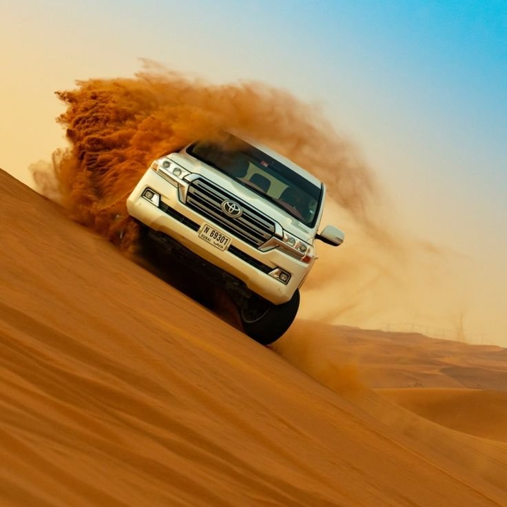 White Land Cruiser speeding through the desert dunes